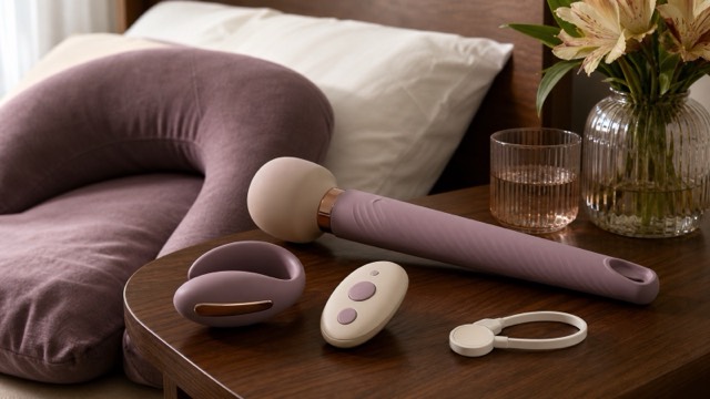 A long-handled massager, wearable vibrator and simple remote arranged within easy reach on a bedside table